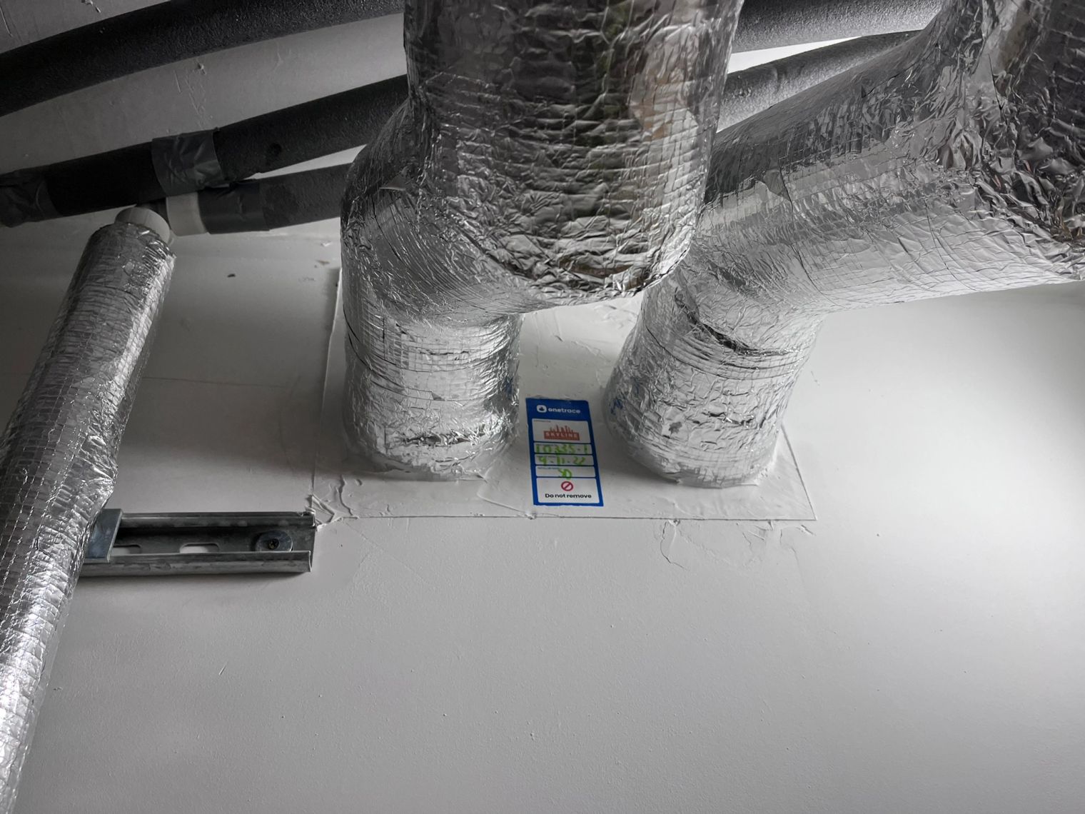 Fire stopping London project: a completed Skyline penetration seal around insulated ductwork, tagged and traceable through its own item-level evidence record