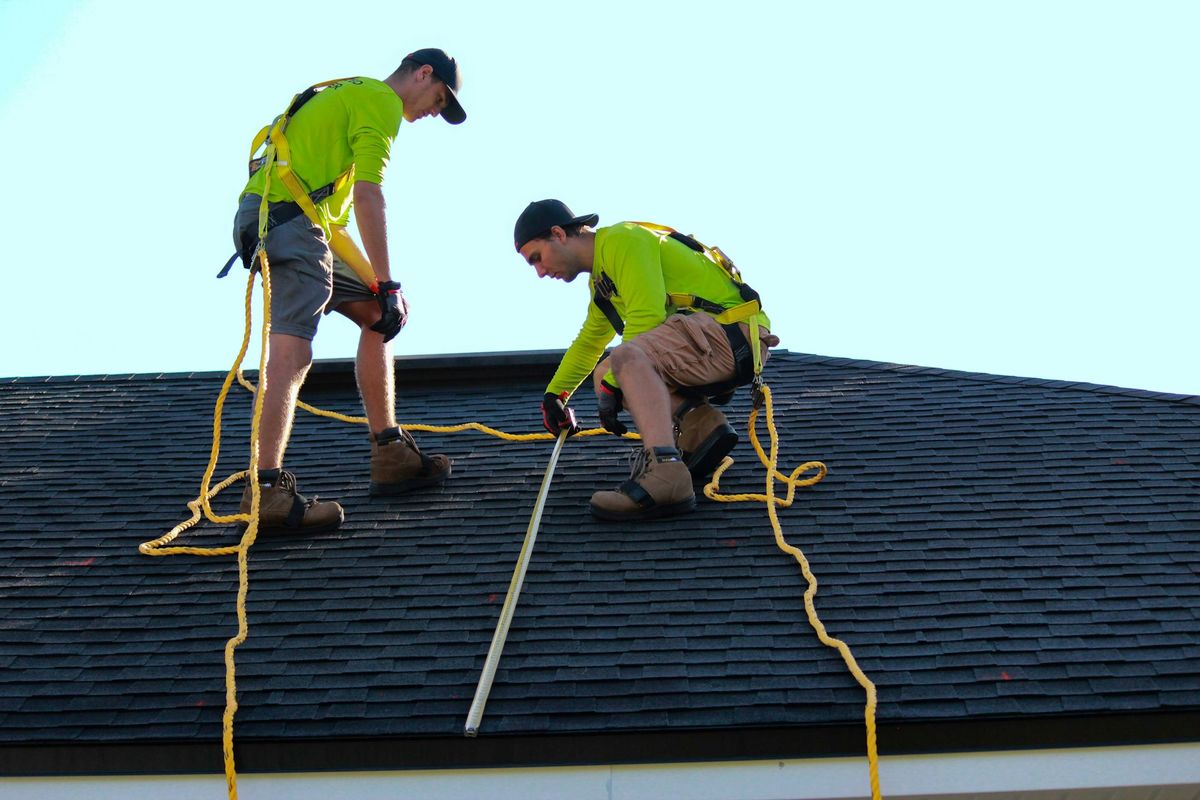 Two roofers working on a residential roof